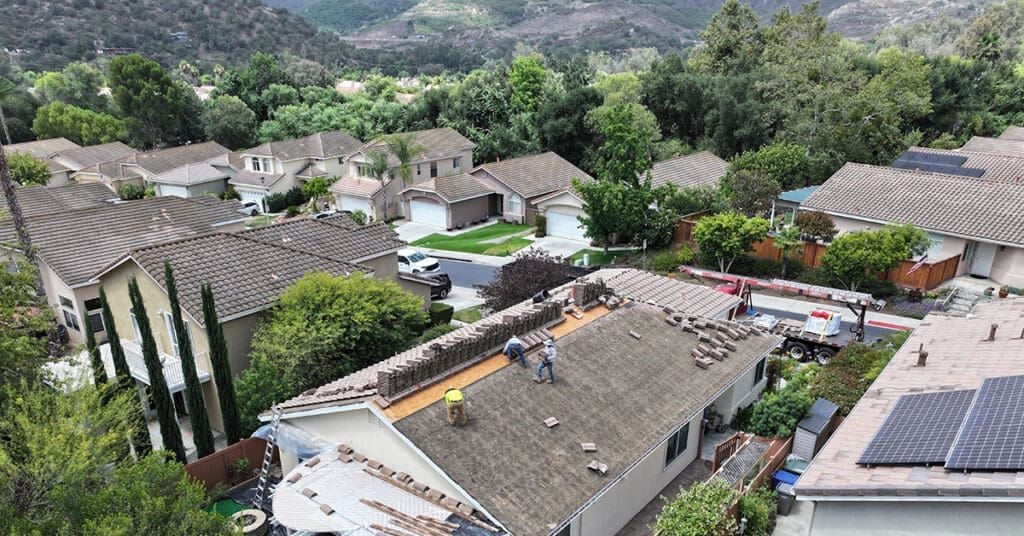Professional roofers from Richardson Roofing removing old tile and preparing the roof deck for a new roof system installation in Escondido.